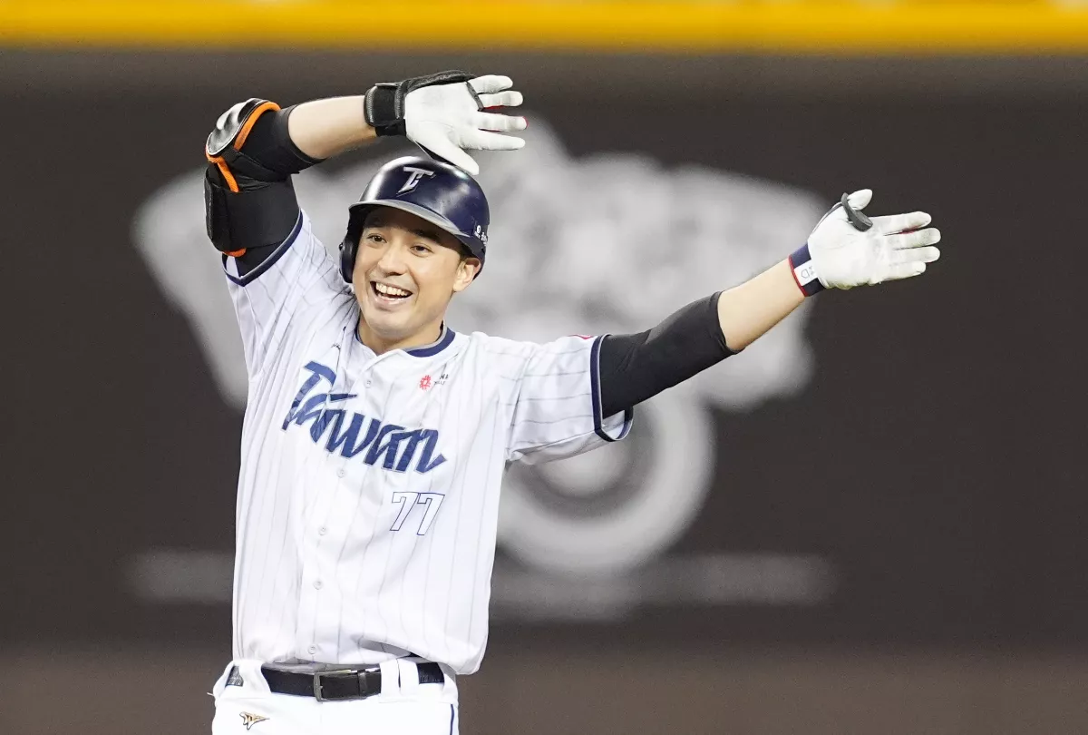 棒球選手穿著白色球衣比賽中揮手慶祝